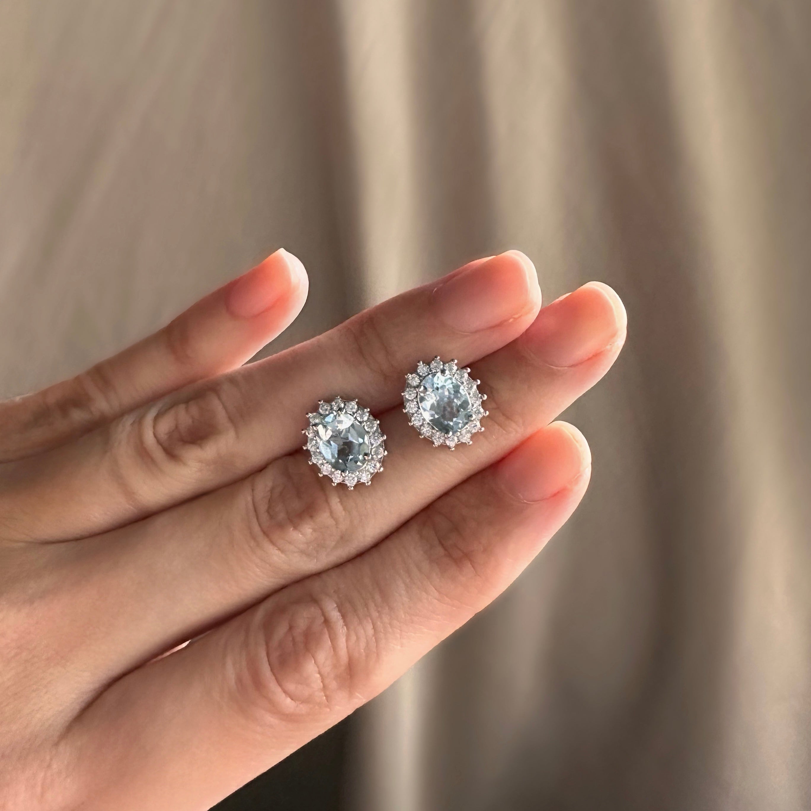 Aretes de plata con topacio azul natural y halo de circonias