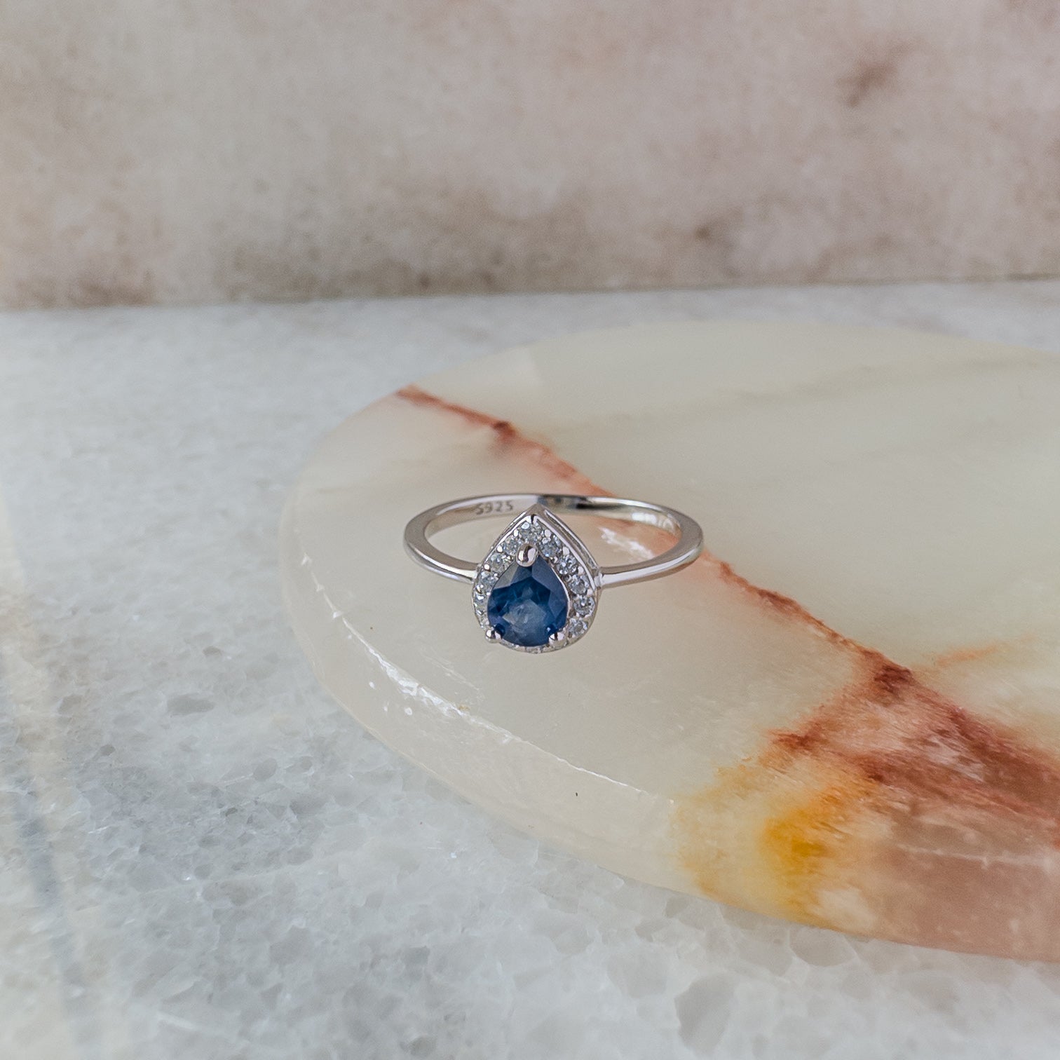 Anillo de plata en forma de gota con zafiro natural y halo de circonias