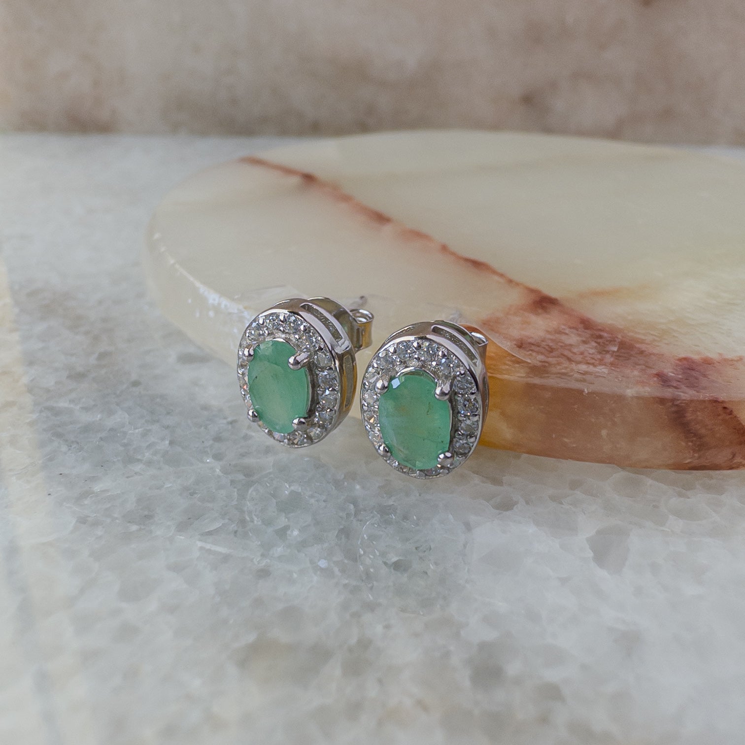 Aretes de plata con esmeralda natural oval y halo de circonias