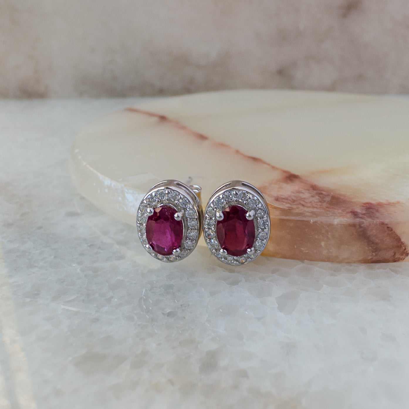 Aretes de plata con rubí natural oval y halo de circonias