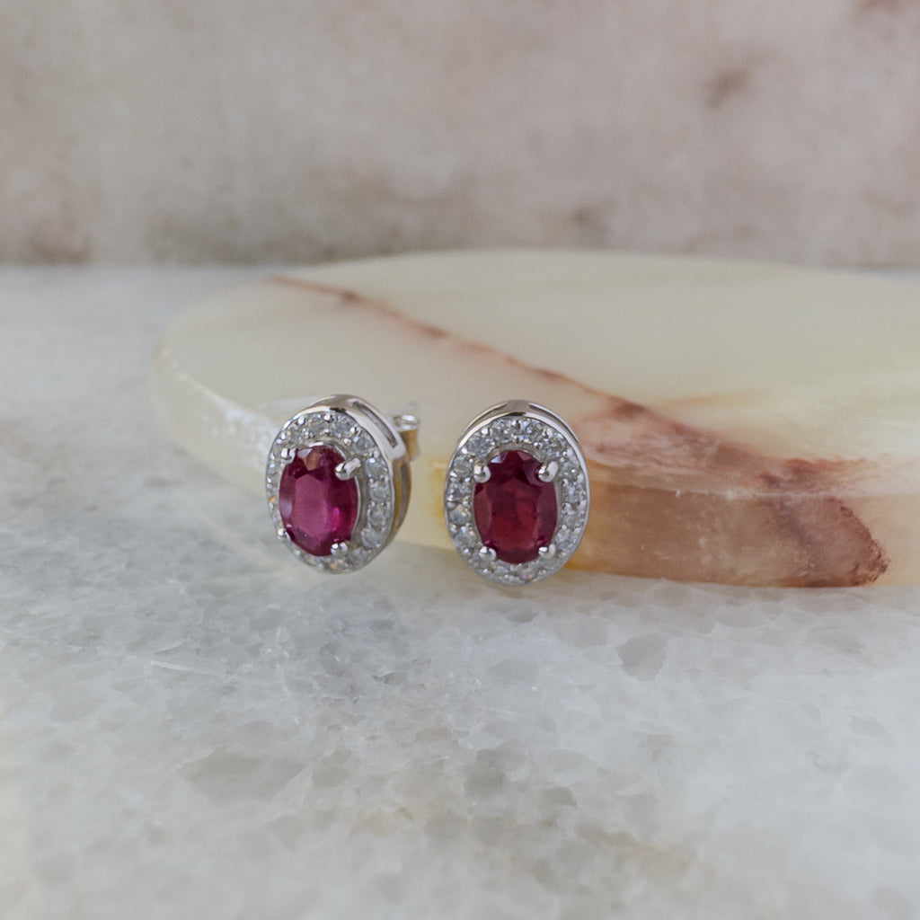 Aretes de plata con rubí natural oval y halo de circonias