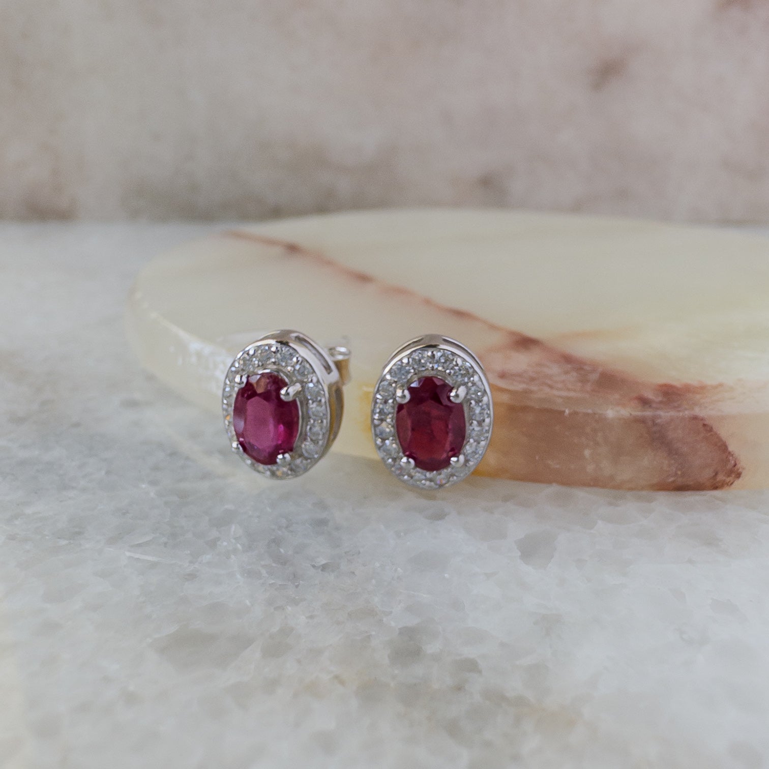 Aretes de plata con rubí natural oval y halo de circonias