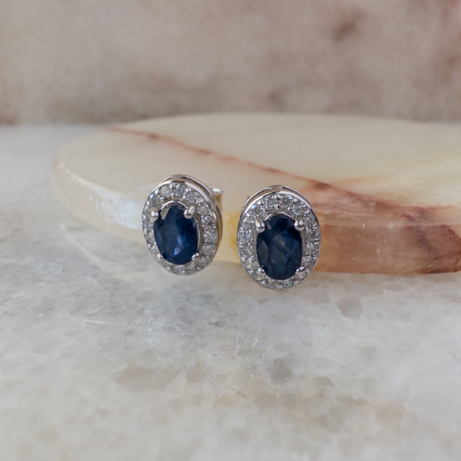 Aretes de plata con zafiro natural oval y halo de circonias