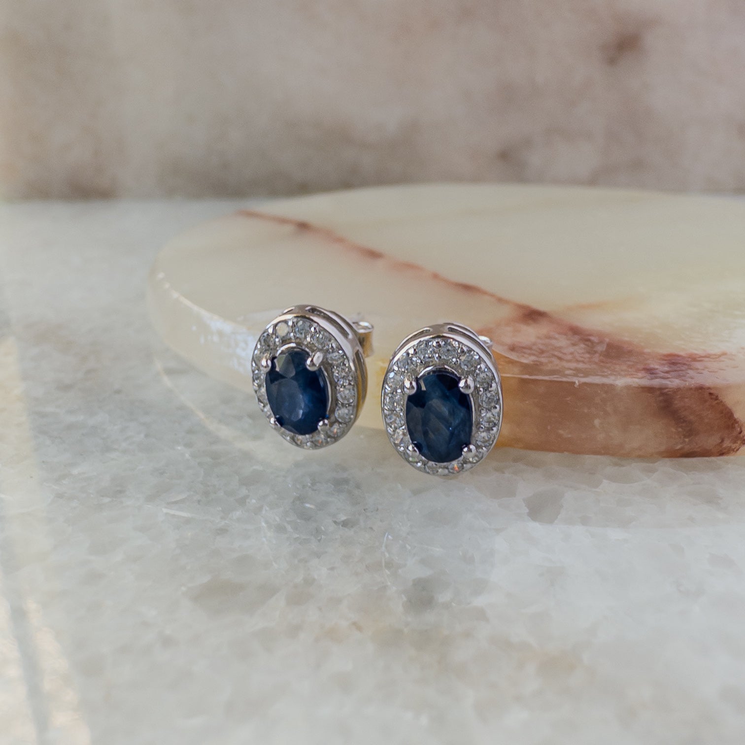 Aretes de plata con zafiro natural oval y halo de circonias