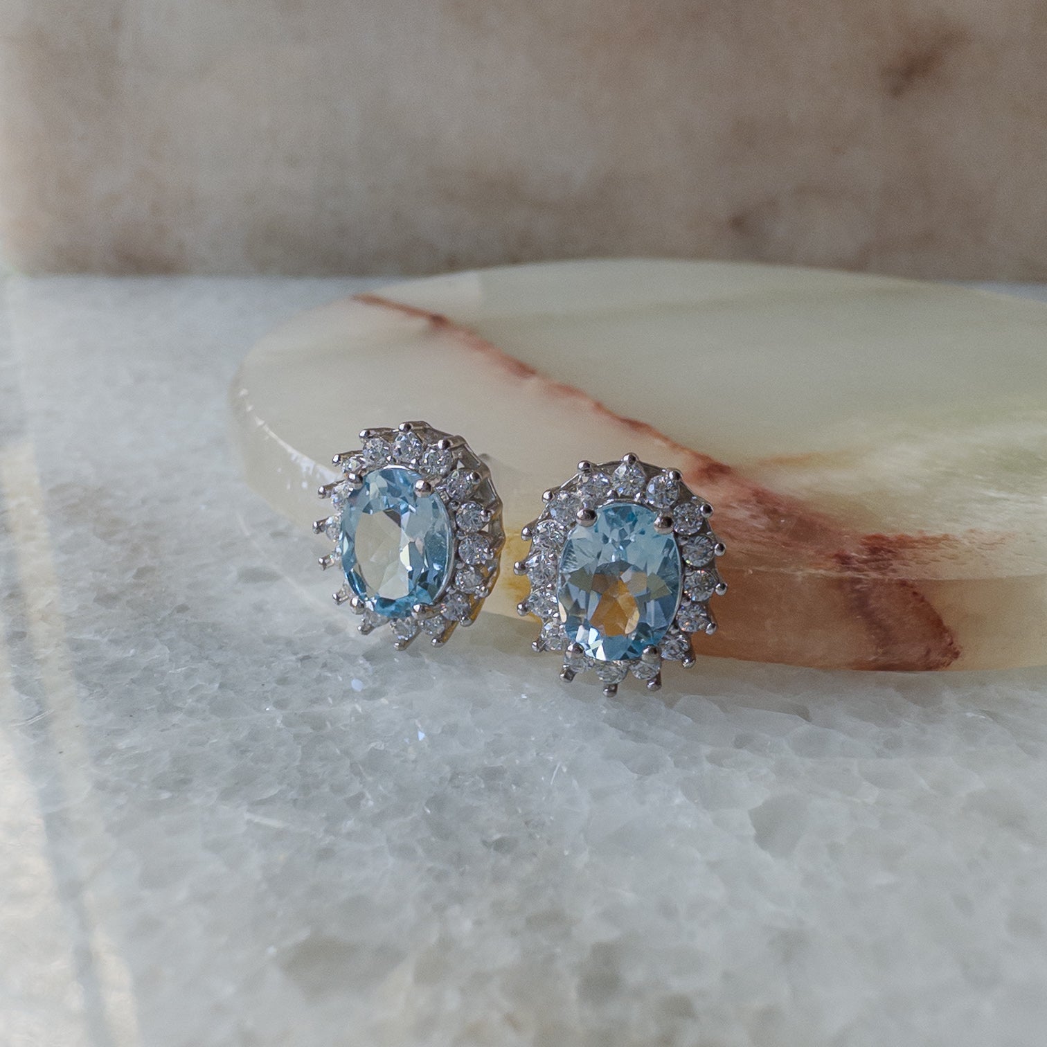 Aretes de plata con topacio azul natural y halo de circonias