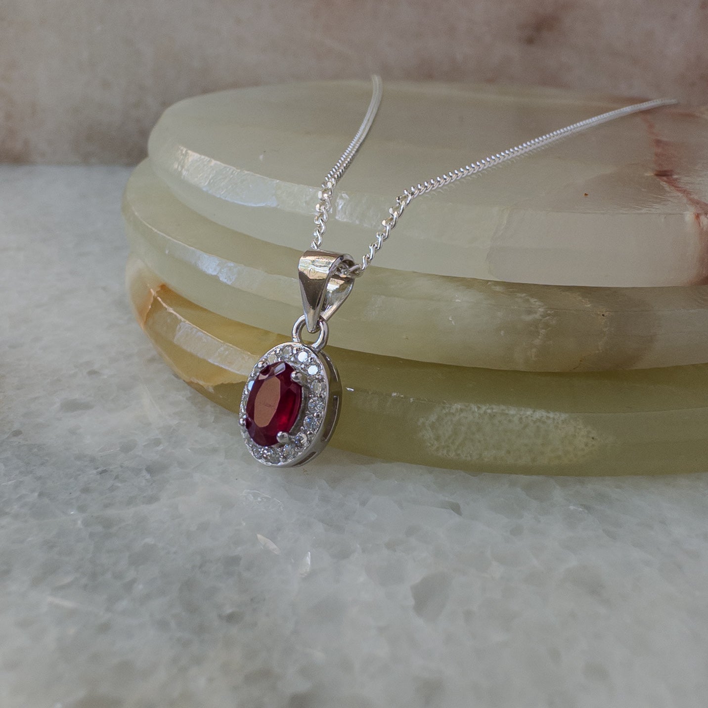 Collar de plata con rubí natural oval con halo de circonias