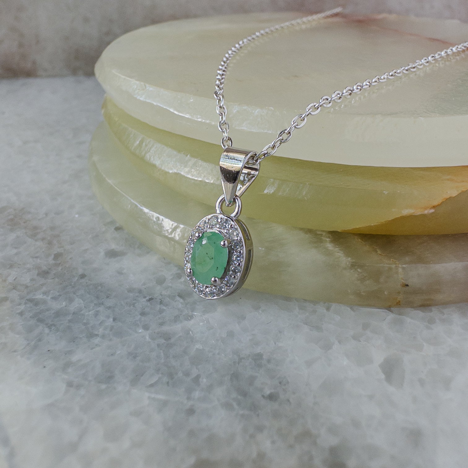 Collar de plata con esmeralda natural oval con halo de circonias